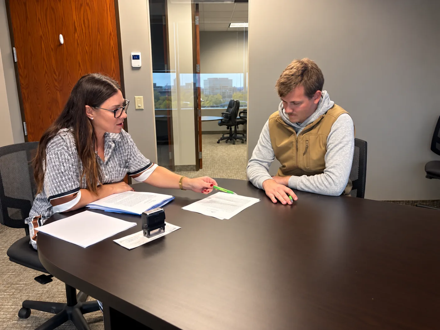 A Pederson Realty agent walking a client through paperwork at the closing table